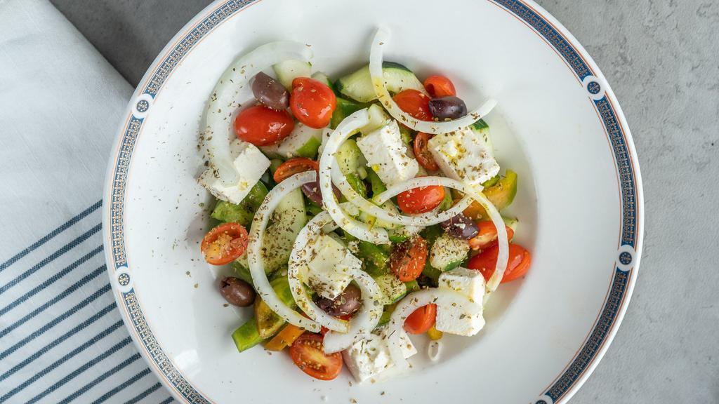 Traditional Horiatiki · Diced tomatoes, cucumbers, red onions, olives, feta, green peppers, and oregano.