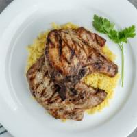 Brizoles Skaras · Charred pork chops with Greek spices served with roasted potatoes.