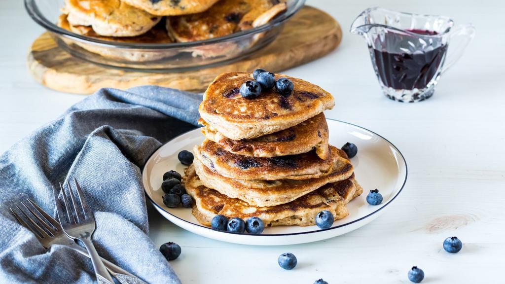 Blueberry Pancakes · Fluffy pancake stack topped with blueberries, butter and syrup.