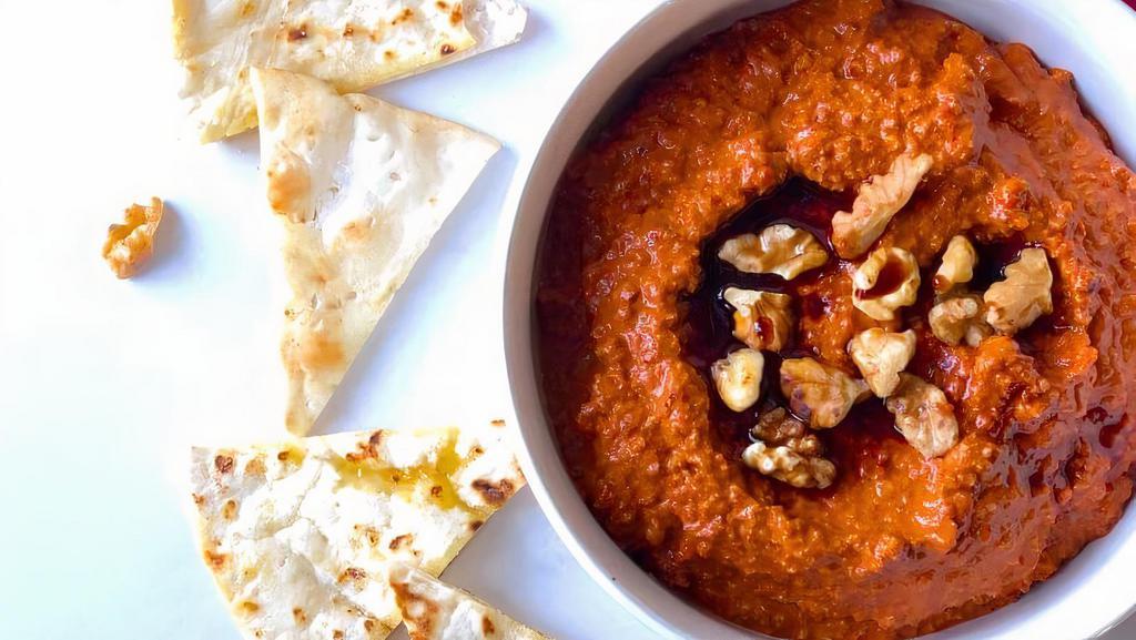 Muhammara Dip · A sweet and savory must try! Roasted red peppers, toasted walnuts, breadcrumbs and pomegranate. Puréed and topped with crushed walnuts.
