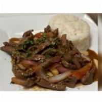 Lomo Sabrosura · Beef sauteed with onions, tomato, soy sauce, and vinegar over fries served with rice, fried ...