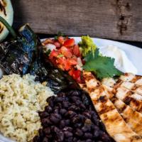 Baja Ranchero · A platter of rice, beans, guacamole, pico de gallo, sour cream, tortillas, a stuffed poblano...