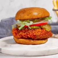 Fiery Nashville Fried Chicken Sandwich · Crispy fried chicken topped with sliced tomatoes, shredded lettuce, dill pickles, and Nashvi...