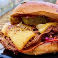 Brisket Sandwich + Fries · Overnight smoked brisket piled with applewood smoked bacon, crispy fried onions, and voodoo ...