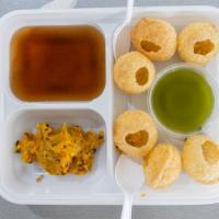 Pani Puri · Crispy puri puffs stuffed with potatoes, chickpeas and served with tamarind sauce.