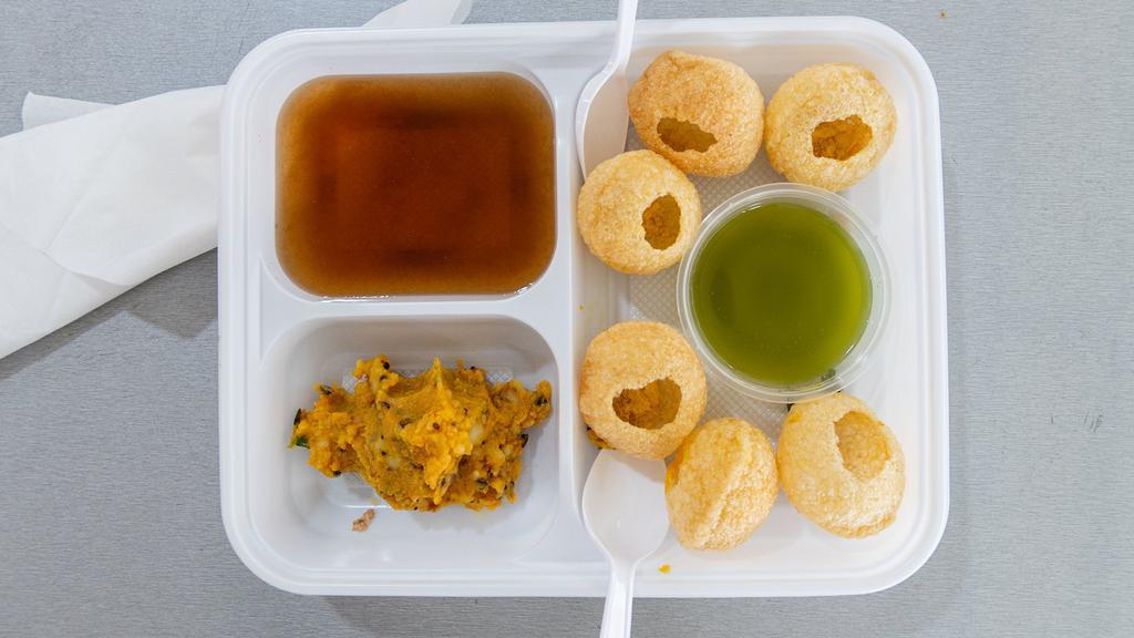 Pani Puri · Crispy puri puffs stuffed with potatoes, chickpeas and served with tamarind sauce.
