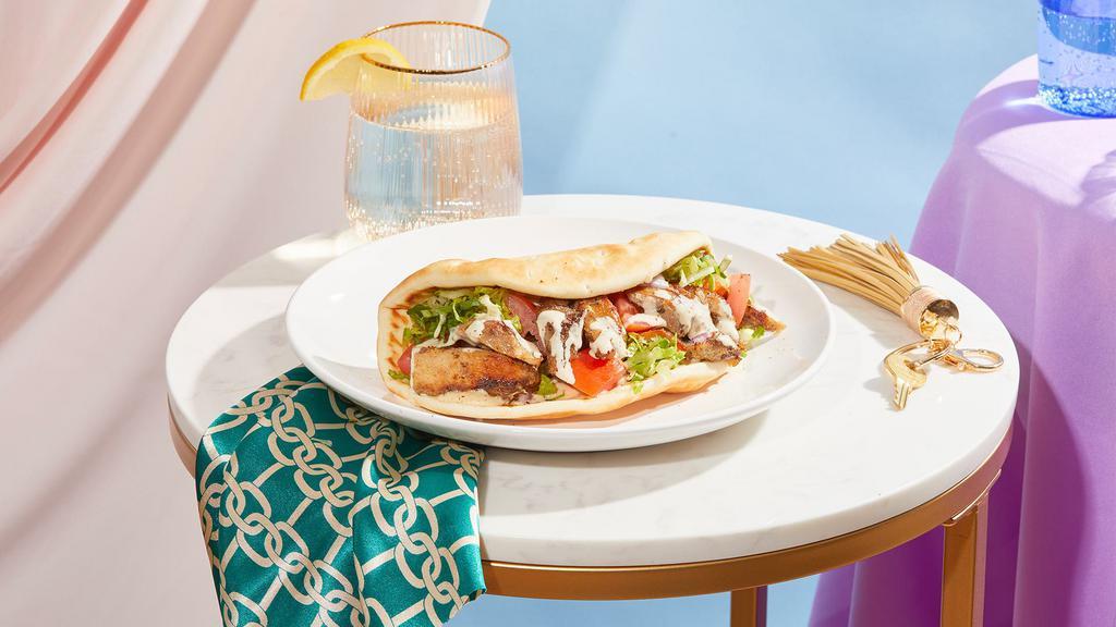 Chicken Shawarma Wrap · Marinated chicken breast with hummus, lettuce, tomato, and red onion drizzled with your choice of sauce and wrapped in a pita.