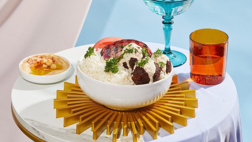 Falafel Bowl · Crispy falafel over rice with hummus, tomatoes, grilled onions, and drizzled with your choice of sauce.