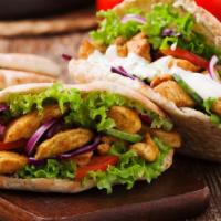 The Chicken Kebab Pita · Thick and fluffy pita bread filled with chicken kebab, lettuce, tomato, onion, and tzatziki ...