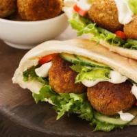 The Falafel Pita · Thick and fluffy pita bread filled with crispy falafel, lettuce, tomato, onion, and tzatziki...