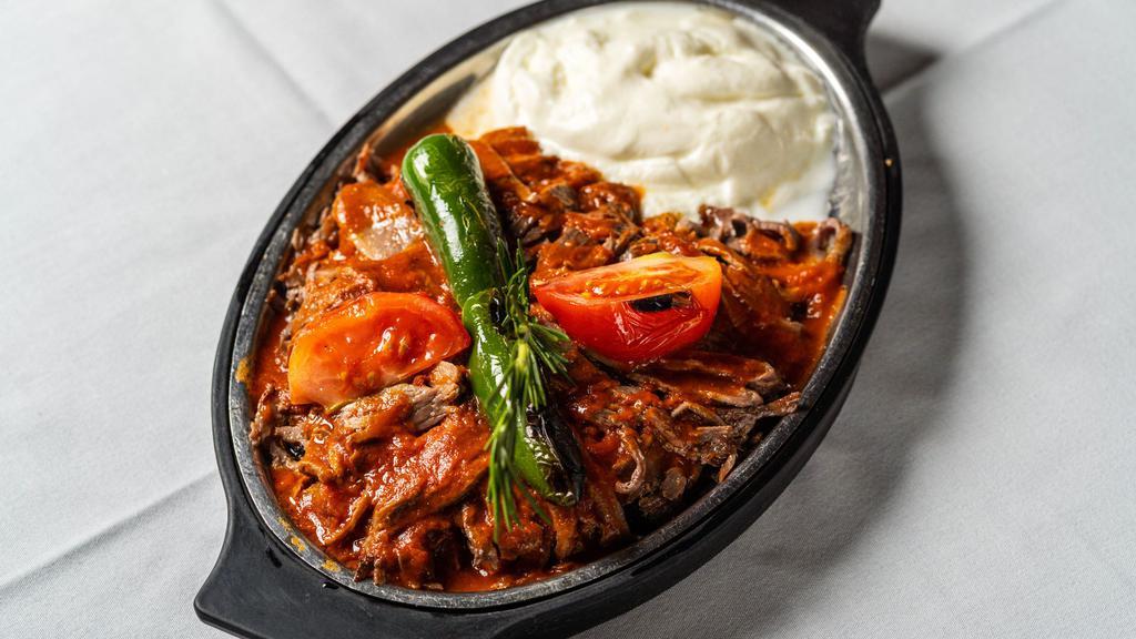 Iskender Kebab · Doner kebab served over bread topped with fresh tomato sauce and a healthy portion of fresh yogurt.