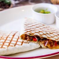 Steak Quesadilla · Grilled steak, sweet onions, sautéed bell peppers, mozzarella, house salsa and guac, with a ...