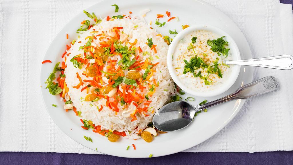 Goat Biryani · Goat on the bone cooked in rice and aromatic spices served with raita.