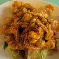 Zabb Popcorn Chicken · Fried chicken with thai seasoning topped with scallion, cilantro,red onion over lettuce. Spi...