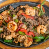 Texas Fajitas · Marinated sliced steak, grilled chicken and shrimp, cooked with bell peppers, onions and tom...