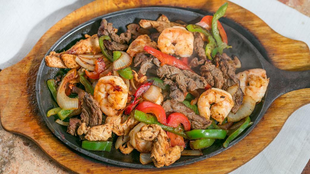 Texas Fajitas · Marinated sliced steak, grilled chicken and shrimp, cooked with bell peppers, onions and tomatoes.