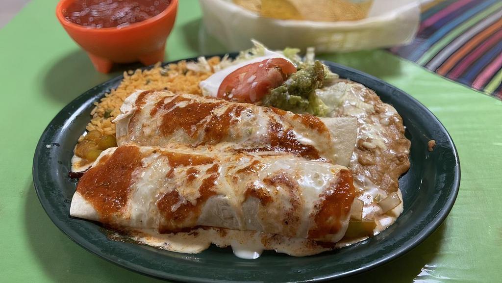 Burritos Mexicanos · Two burritos filled with grilled chicken or steak. sautéed onions. tomatoes, bell peppers, beans, cheese sauce and burrito sauce, served with guacamole salad, rice and beans
