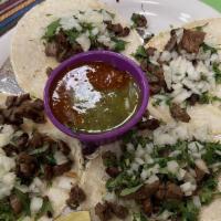 Tacos Carne Asada · Three flour tortillas or four corn tortillas with grilled steak, served with rice, beans, Pi...