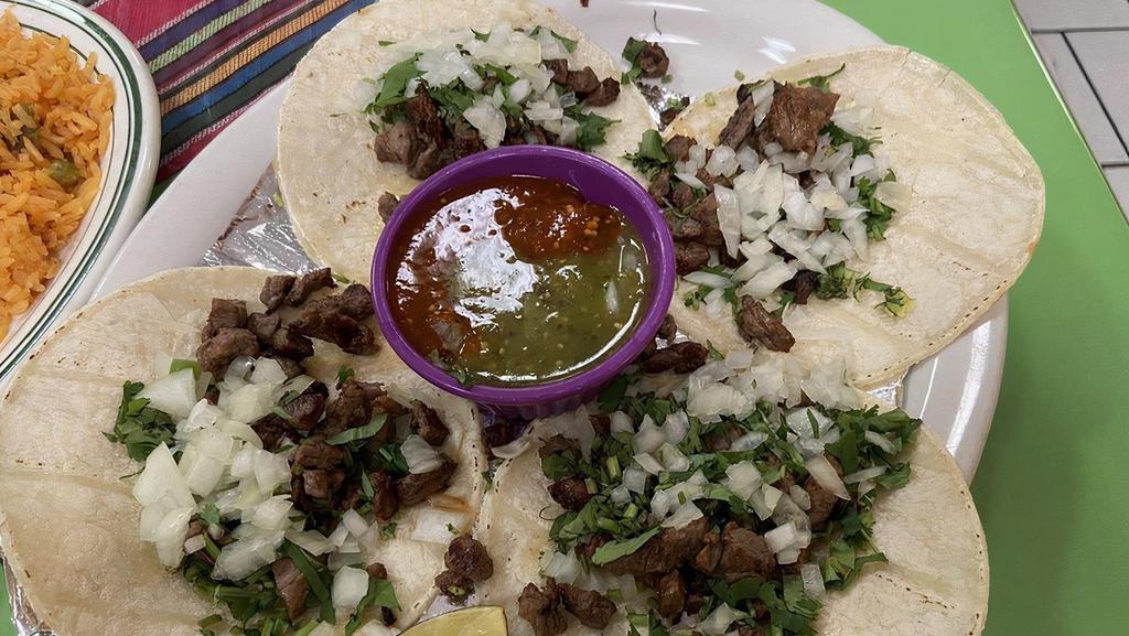 Tacos Carne Asada · Three flour tortillas or four corn tortillas with grilled steak, served with rice, beans, Pico de Gallo, tomato sauce. cilantro. onion and time.