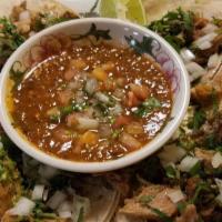 Tacos De Carnitas · Three flour tortillas or four corn tortillas with caritas, cilantro and onions, served with ...