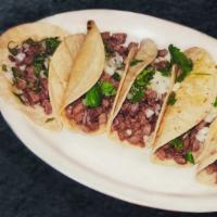 Carne Asada  · Thin sliced grilled steak, covered with grilled onions, served with rice and beans, guacamol...