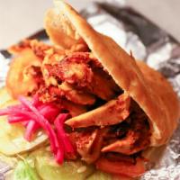 Chicken Shawarma Pita · Thinly sliced roasted chicken, lettuce, tomatoes, pickles, garlic sauce.