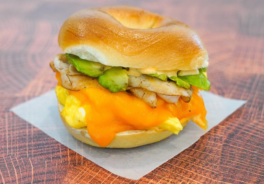 Bagel, Smoked Turkey, Avocado, Egg, & Cheddar Sandwich · 2 scrambled eggs, melted Cheddar cheese, sliced smoked turkey, avocado, and Sriracha aioli on a toasted bagel.