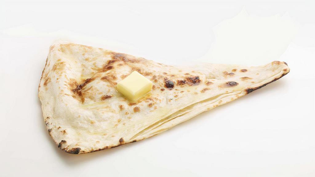 Butter Naan · Traditional Indian refined flour bread cooked in oven tandoor and layered with butter.