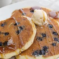 Blueberry Buttermilk Pancakes · Three buttermilk pancakes loaded with juicy blueberries, grilled and sprinkled with powdered...