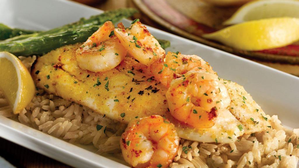 Grilled Tilapia With Shrimp · Garlic seasoned tilapia topped with grilled shrimp and drizzled with garlic butter. Served over herb rice pilaf with grilled asparagus.