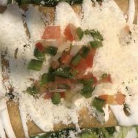 Flautas De Pollo · Three stuffed crispy taquitos with seasoned shredded chicken topped with cotija cheese and M...