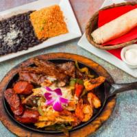 Azteca Fajitas · A combination of grilled chicken, skirt steak, mayan shrimp, chorizo with bell peppers, onio...