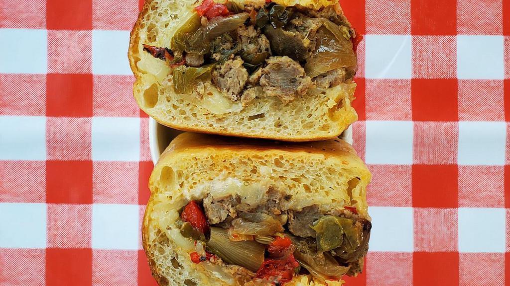 Sausage & Peppers Hero · Housemade italian sausage, provolone, roasted hot & sweet peppers, roasted onion, mayo on a housemade seeded hero roll.