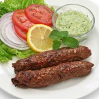 The Lamb Seekh Kebab · Exquisite grounded lamb seasoned with ginger, garlic, red onions and cilantro.
