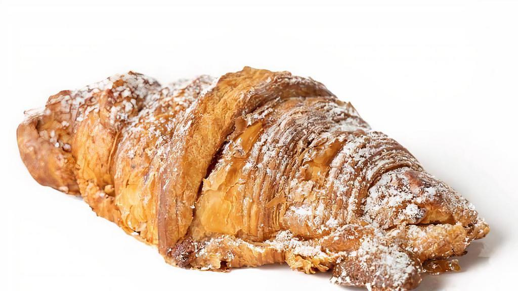 Croissant Aux Amandes  · Flaky all butter yeast puff-pastry dough filled with a rich, almond flan and topped with sliced almonds and powdered sugar.