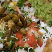 Nachos Regulares · Nachos with beans, cheese, sour cream, tomato, jalapenos, onions, cilantro, and avocado.