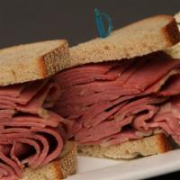 Hot Corned Beef Sandwich · Overstuffed, piled high and served with a side of cole slaw and a pickle.