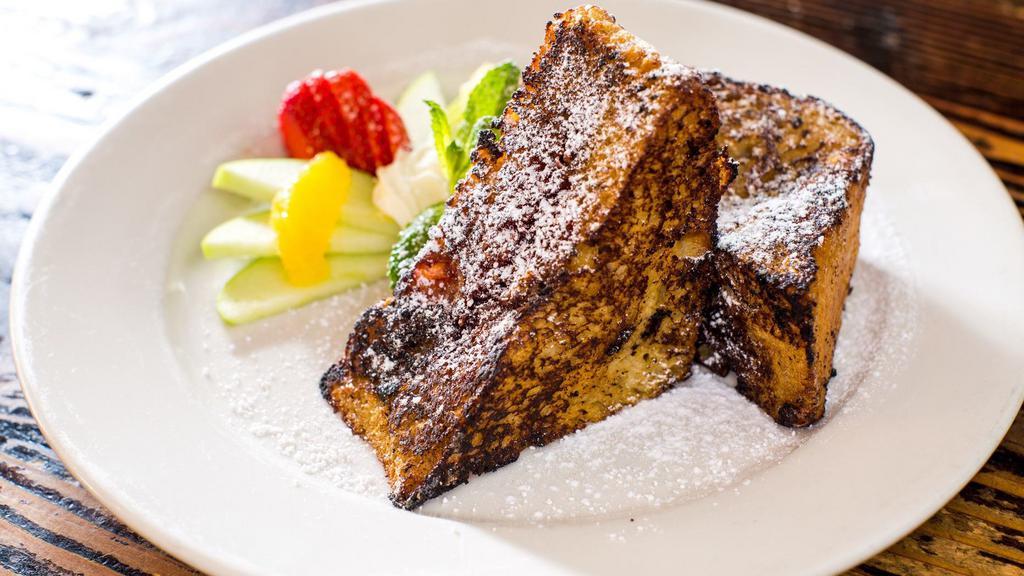 Dino French Toast · Thick-sliced pullman bread stuffed with raspberry jelly. Served with mixed fruit and maple syrup.
