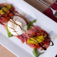 Antipasto · Burrata mozzarella and roasted red peppers over prosciutto topped with basil oil and a fig b...