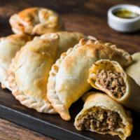 Beef Empanadas · Crispy fried flour pastry filled with ground beef, olive oil, fresh Sofrito, and mixed herbs...