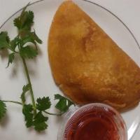 Empanada De Carne · Cornmeal empanada stuffed with picadillo (ground meat, potatoes and carrots) with our delici...