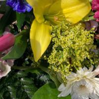 Easter Bouquet · Assorted Spring flowers hand wrapped with greenery, filler, in clear cellophane and tissue a...