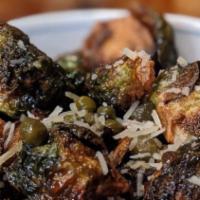Crispy Brussels · sautéed brussels rendered and topped in smoked farmhouse bacon, shoyu and shaved parmesan ch...
