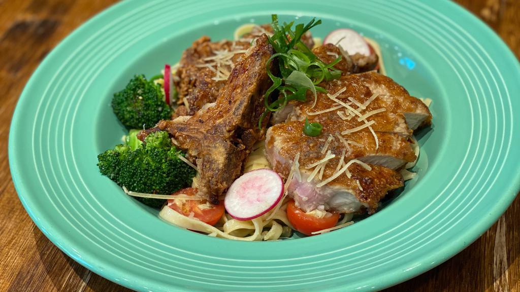 Grandmas Fried Pork Chop Pasta · 10oz battered pork chop fried golden brown served on top a bed of fettuccini pasta tossed in a garlic lemon caper sauce topped with parmesan cheese served with sautéed broccoli and cherry tomatoes
