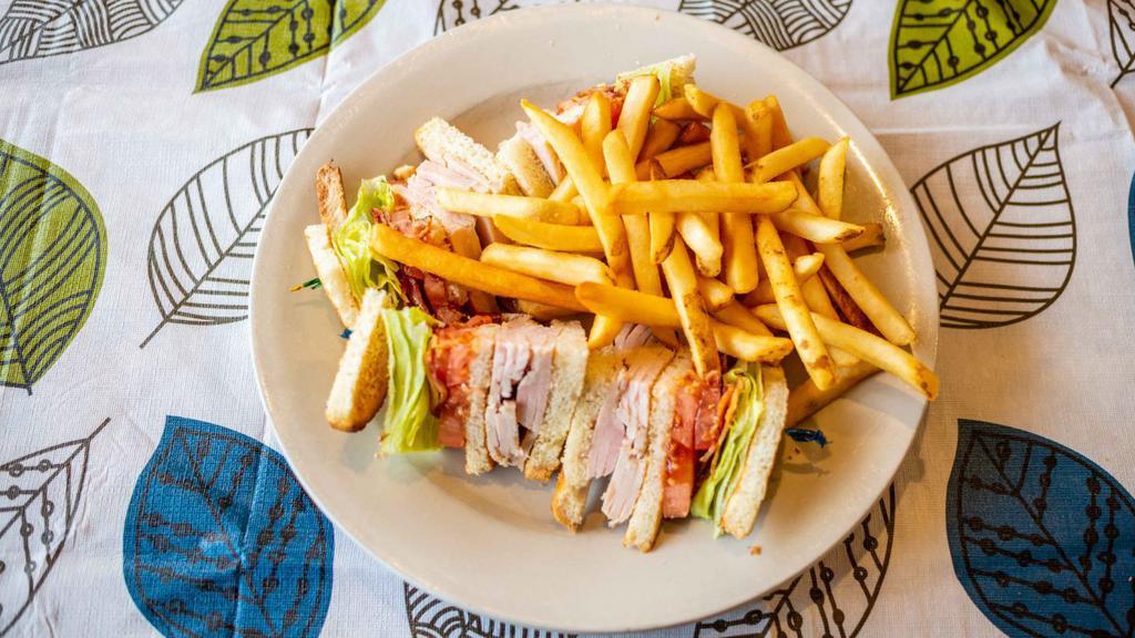 Turkey Club Sandwich · Served with bacon, lettuce and tomato. Served with french fries, coleslaw and pickles.