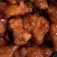 Sesame Chicken · Chunks of white meat chicken with brown sauce and broccoli with sesame seeds on top.