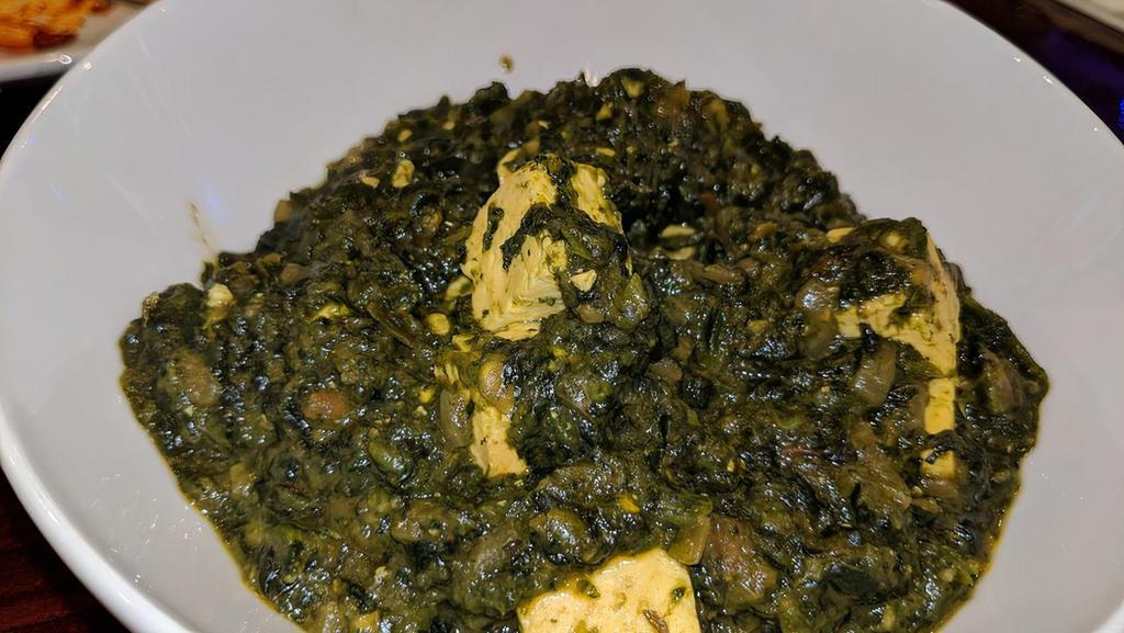 Saag · Spinach cooked with onion, tomatoes, garlic, and spices flavored with fenugreek leaves.