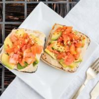 Avocamuss Toast · Hummus, avocado, diced tomato, crushed red pepper flakes and a drizzle of lemon juice on a t...