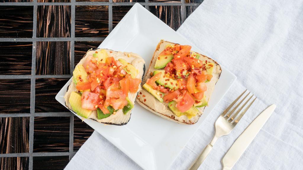 Avocamuss Toast · Hummus, avocado, diced tomato, crushed red pepper flakes and a drizzle of lemon juice on a toasted focaccia square