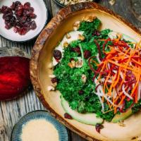 Kale Avocado Salad · Kale, walnuts, and cranberries tossed with citrus aminos, and topped with carrots, beets, da...